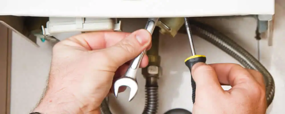 Boiler repair technician tightening pipe fittings and connections in Saint Louis, MO