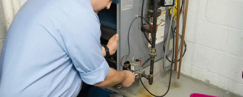 Furnace repair technician inspecting and servicing a home heating system in Saint Louis, MO