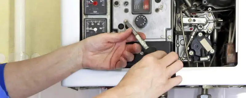 Heating repair technician adjusting boiler controls and components in Saint Louis, MO
