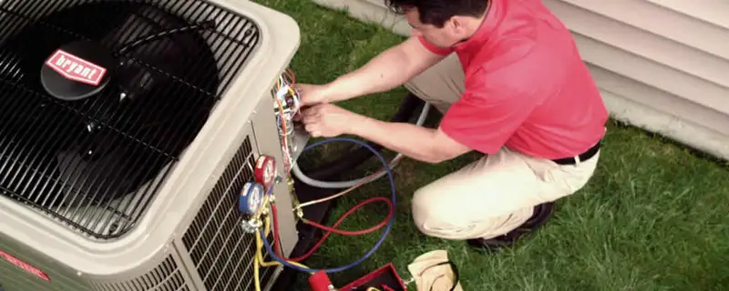 HVAC technician servicing an outdoor air conditioner unit in Saint Louis, MO