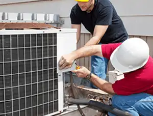 HVAC technicians repairing an outdoor AC unit on a rooftop in Saint Louis, MO