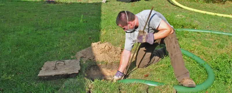 Septic pumping technician servicing a residential septic tank in Saint Louis, MO