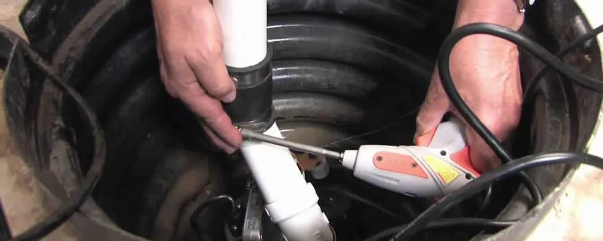 Sump pump installation technician connecting PVC discharge piping in Saint Louis, MO