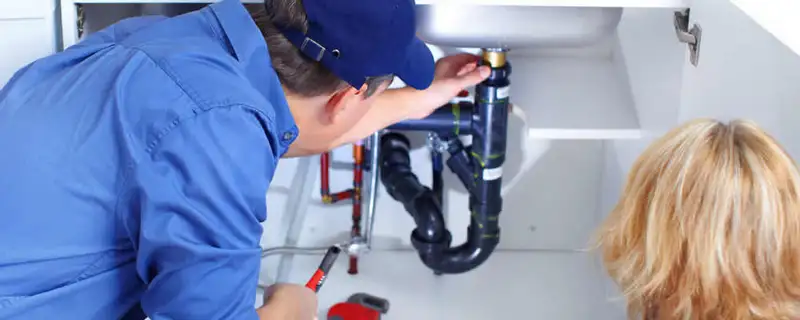 Plumber repairing under-sink drain pipes and fittings in Saint Louis, MO